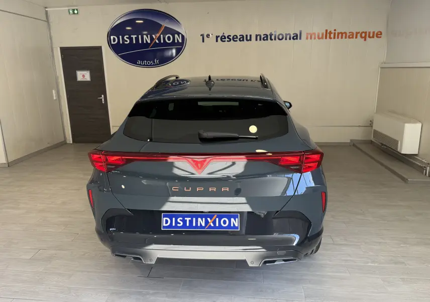 Vue arrière d'une CUPRA Formentor gris foncé 2026 avec feux LED reliés et logo distinctif au centre du hayon.