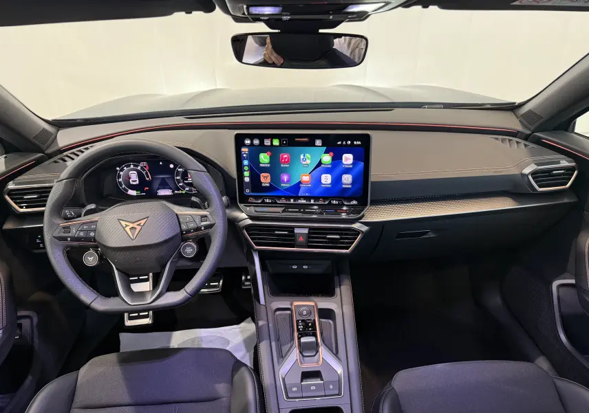 Vue intérieure frontale du tableau de bord gris du CUPRA Formentor 1.5 eTSI 2026 avec écran tactile central et volant multifonction.