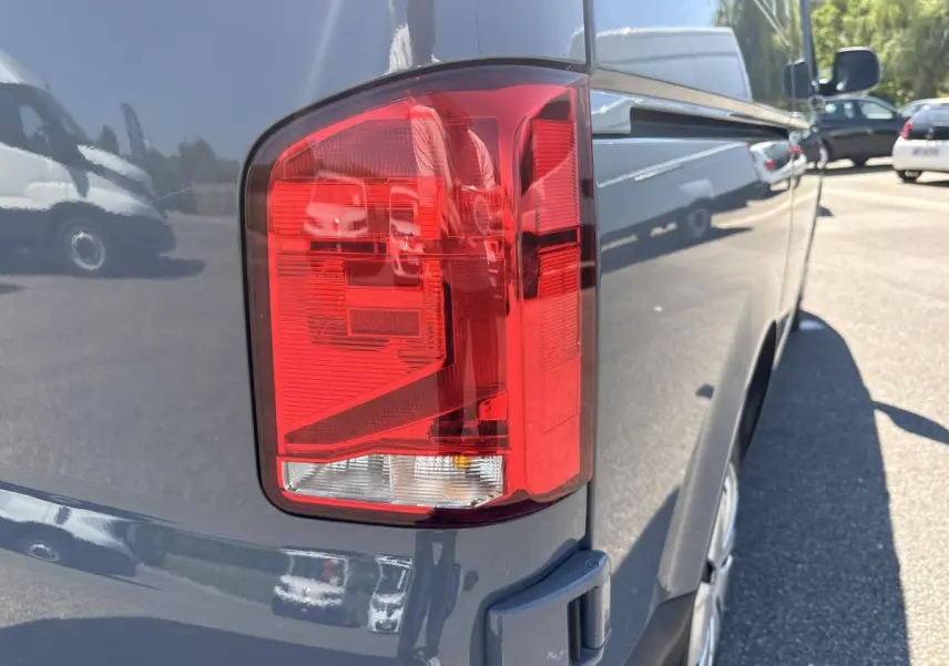 Gros plan sur le feu arrière droit d’un Volkswagen Transporter gris clair 2023, vue latérale arrière.