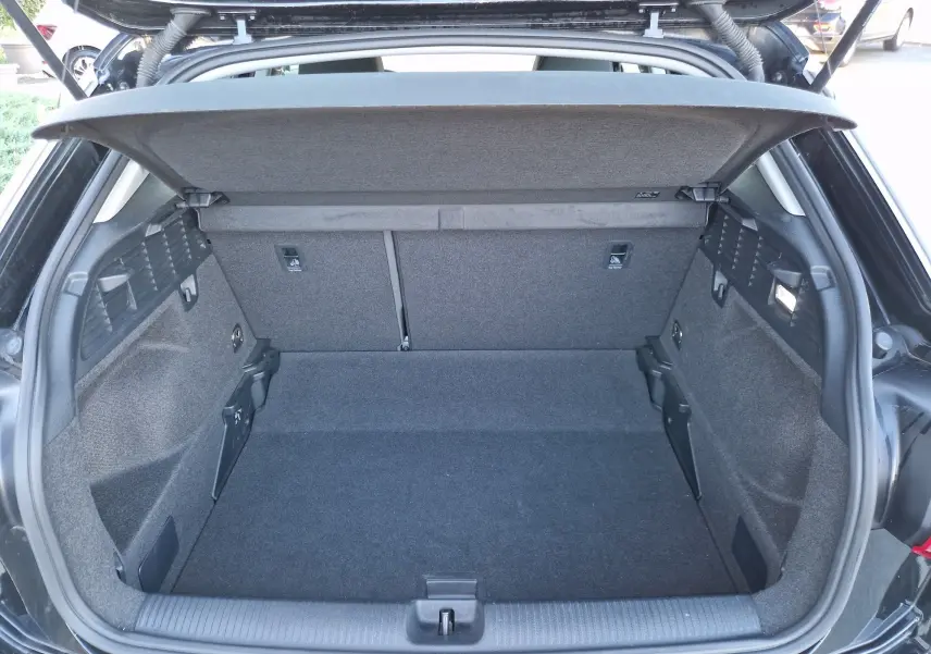 Coffre ouvert vu de l'arrière d'un Audi Q2 noir 2021, montrant un espace de chargement propre et bien agencé.
