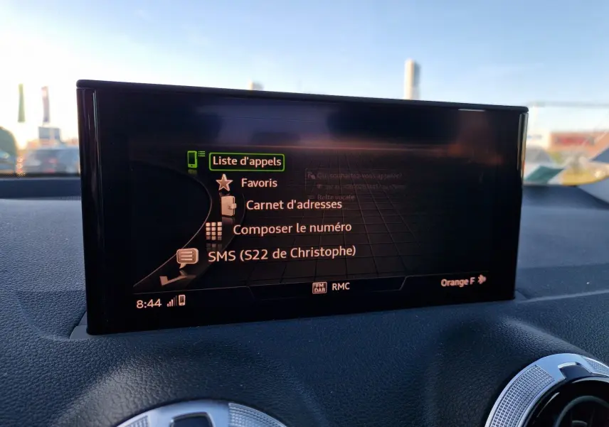 Écran central de l’Audi Q2 2021 affichant le menu appels avec options favoris, carnet d’adresses et SMS, intérieur noir.