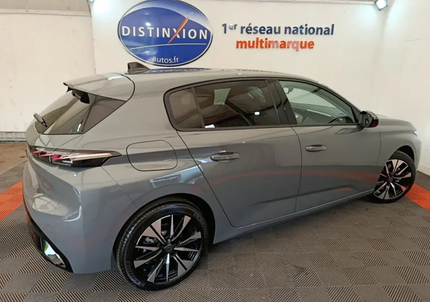 Peugeot 308 BlueHDi 130 gris foncé vue 3/4 arrière droit, jantes alliage noires et feux LED fins.