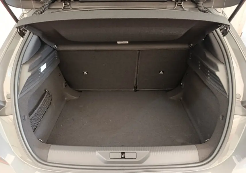 Coffre ouvert vu de l'arrière d'une Peugeot 308 gris foncé, montrant un espace de chargement propre et spacieux.