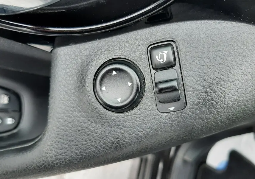 Gros plan sur les commandes de réglage des rétroviseurs côté conducteur du Nissan Qashqai noir 2020.