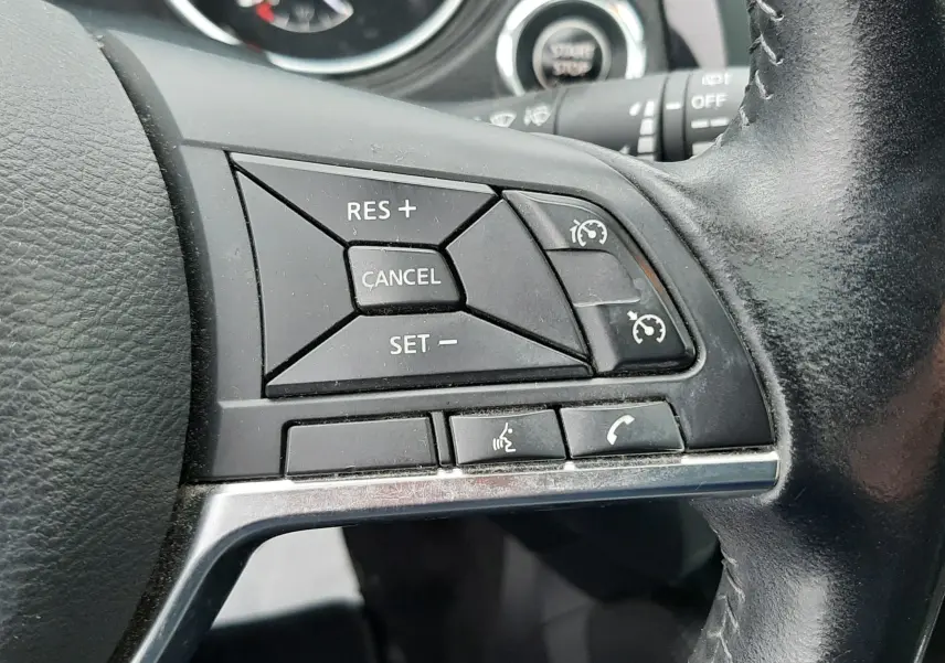 Gros plan sur les commandes de régulateur de vitesse au volant cuir noir du Nissan Qashqai DCI 115 N-Connecta 2020.
