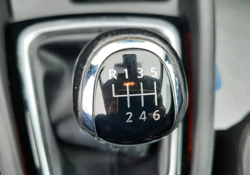 Gros plan sur le levier de vitesses manuel noir du Nissan Qashqai DCI 115 N-Connecta 2020, avec marquages blancs.