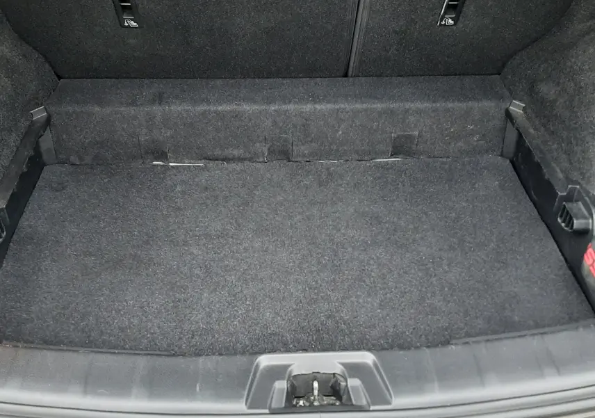 Vue du coffre ouvert du Nissan Qashqai DCI 115 N-Connecta noir de 2020, montrant un espace de rangement propre et tapissé.