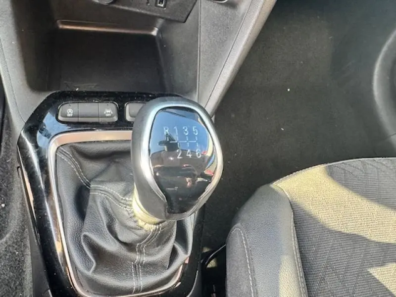 Gros plan sur le levier de vitesses manuel noir et argenté de l'Opel Corsa 1.2 Turbo 2022, côté siège conducteur.