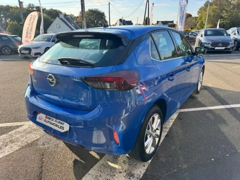 Vue 3/4 arrière droite d'une Opel Corsa 1.2 Turbo 100ch Elegance bleu voltaïque métallisé avec jantes alu et becquet noir.