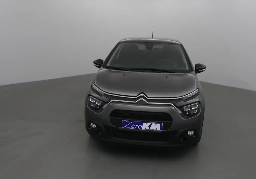 Vue frontale d'une Citroën C3 2022 gris platinium avec calandre noire et phares LED distinctifs.