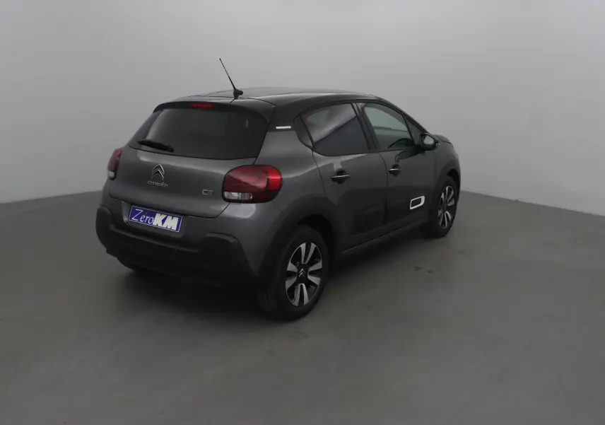 Citroën C3 2022 gris platinium et noir vue 3/4 arrière droit avec jantes biton et détails blancs sur porte.