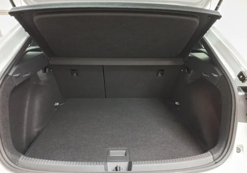 Vue arrière du coffre ouvert du Volkswagen Taigo blanc pur 2025, version R-Line avec toit ouvrant, montrant l'espace de chargement vide.