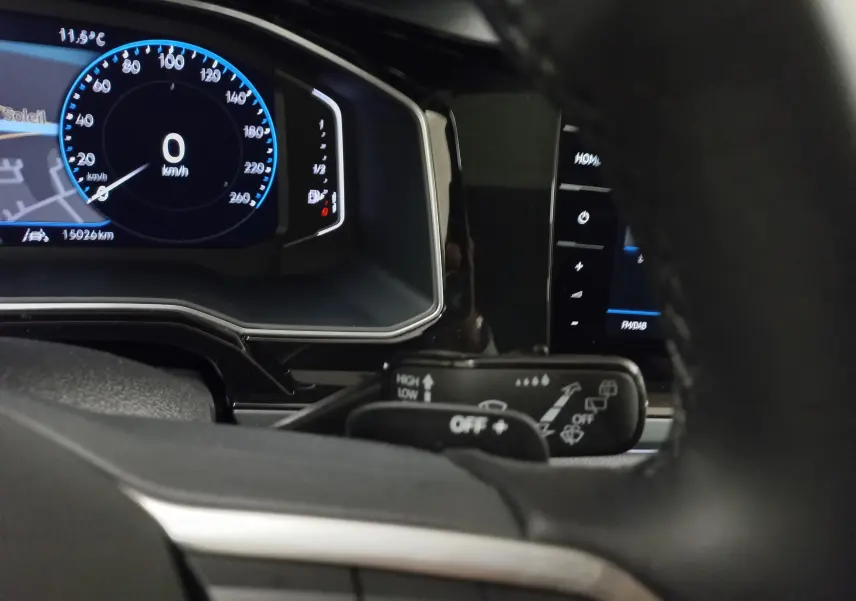 Vue rapprochée du tableau de bord digital du Volkswagen Taigo blanc pur 2025, avec affichage vitesse et commandes au volant.