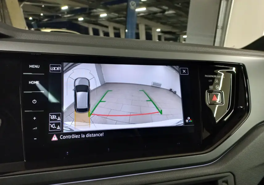 Vue intérieure de l'écran multimédia du Volkswagen Taigo blanc, affichant la caméra de recul avec guidage de trajectoire.