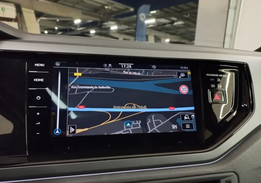 Vue intérieure du tableau de bord du Volkswagen Taigo blanc 2025, avec écran tactile de navigation allumé.