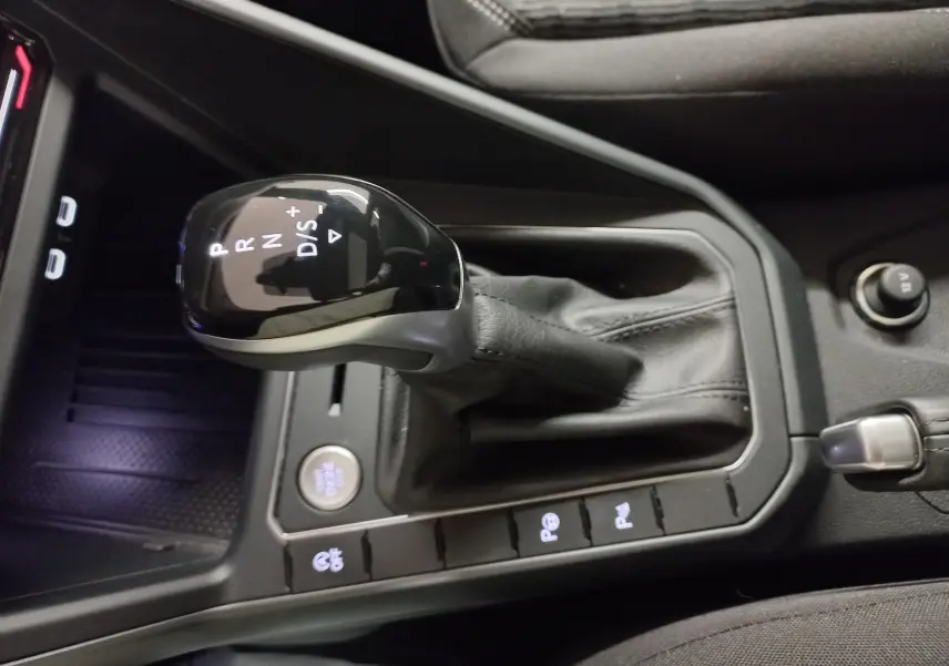 Le levier de vitesse automatique noir du Volkswagen Taigo 2025, vue rapprochée de la console centrale intérieure.