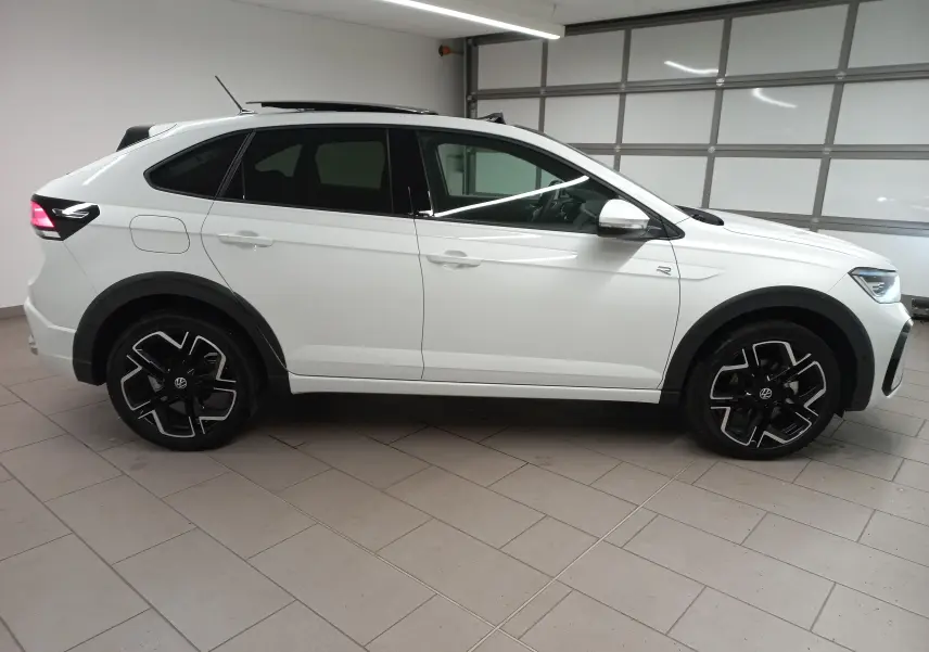 Vue de profil côté gauche du Volkswagen Taigo blanc pur 2025, version R-Line avec jantes noires distinctives.