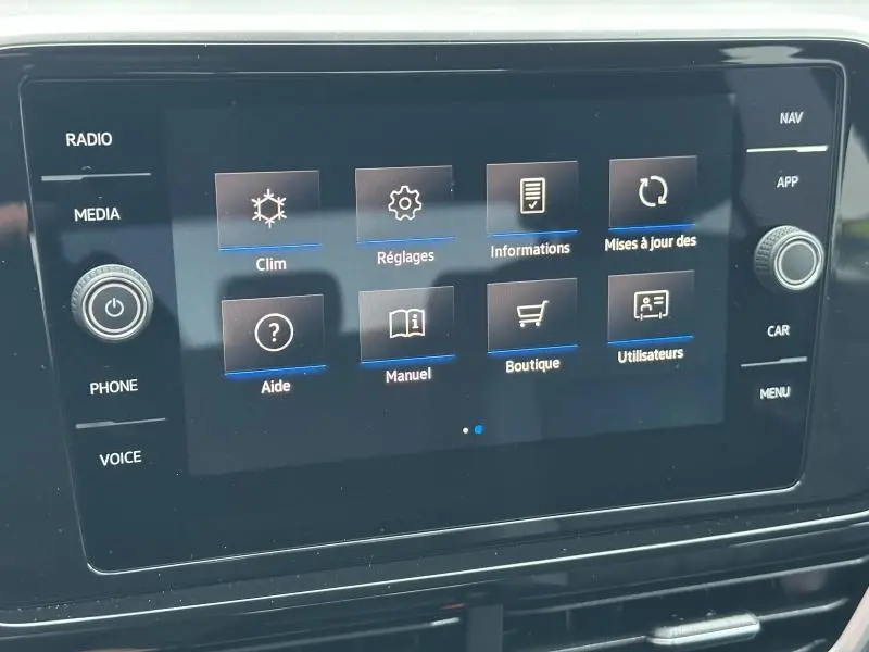 Écran tactile central du Volkswagen T-Roc 2025 affichant le menu principal avec options clim, réglages et informations.
