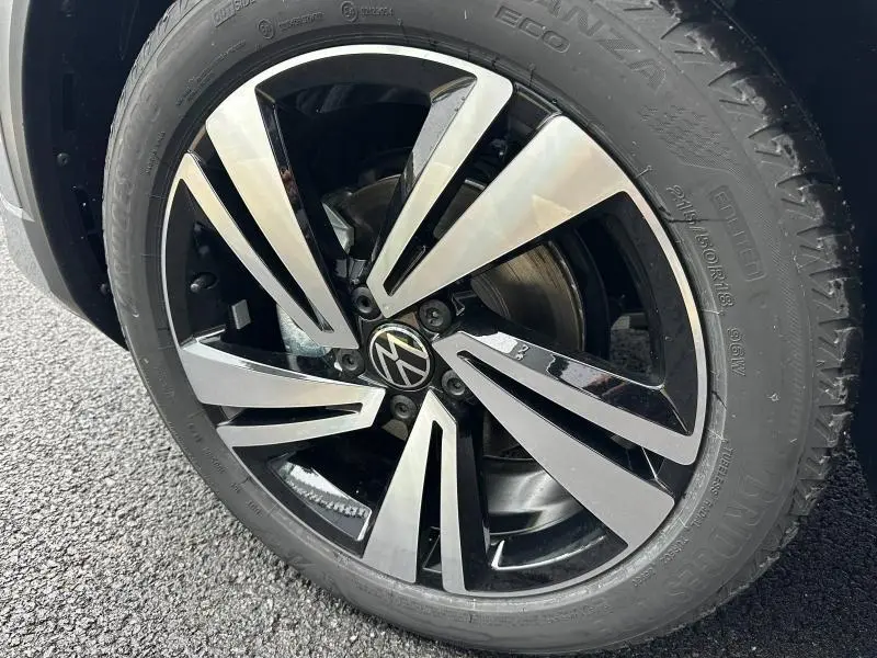 Gros plan sur la jante alu bicolore et le pneu Bridgestone du Volkswagen T-Roc gris 2025, version R-Line Edition.