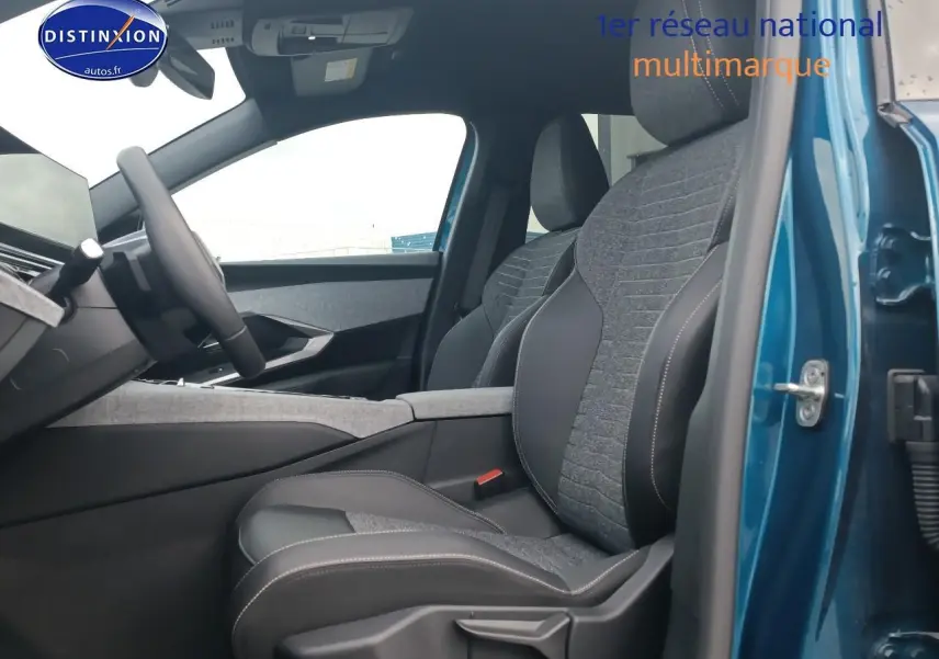 Intérieur du Peugeot 3008 bleu 2025 vu côté conducteur, montrant les sièges en tissu et cuir avec console centrale grise.