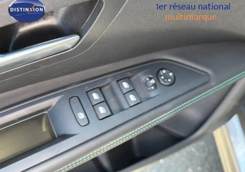 Détail de la porte côté gauche du Peugeot 3008 gris Artense, avec commandes des vitres et rétroviseurs, surpiqûres bleues visibles.