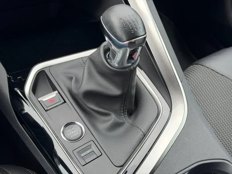 Gros plan sur la boîte manuelle et le levier de vitesses du Peugeot 3008 Gris Platinium, avec bouton start/stop et mode sport.