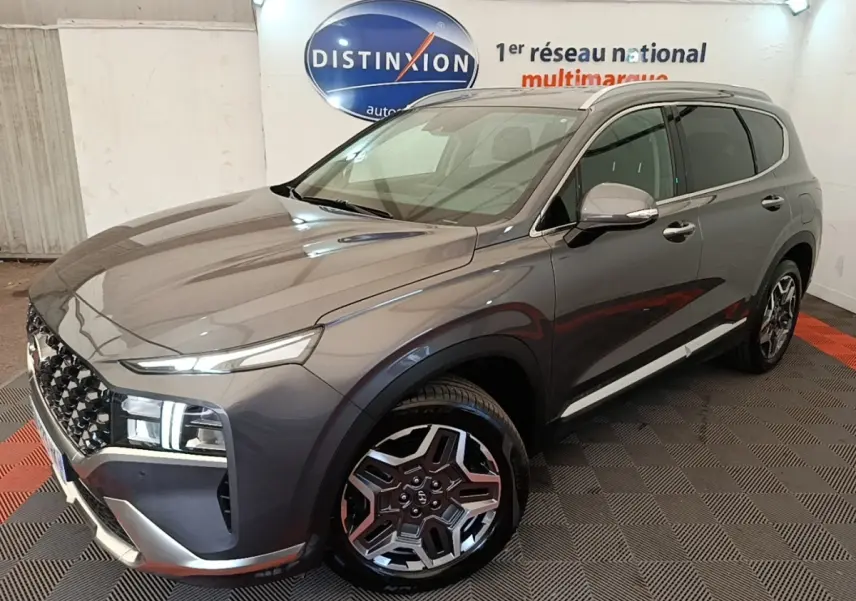 Vue 3/4 avant droit du Hyundai Santa Fe gris foncé 2023 avec jantes alliage et calandre distinctive.