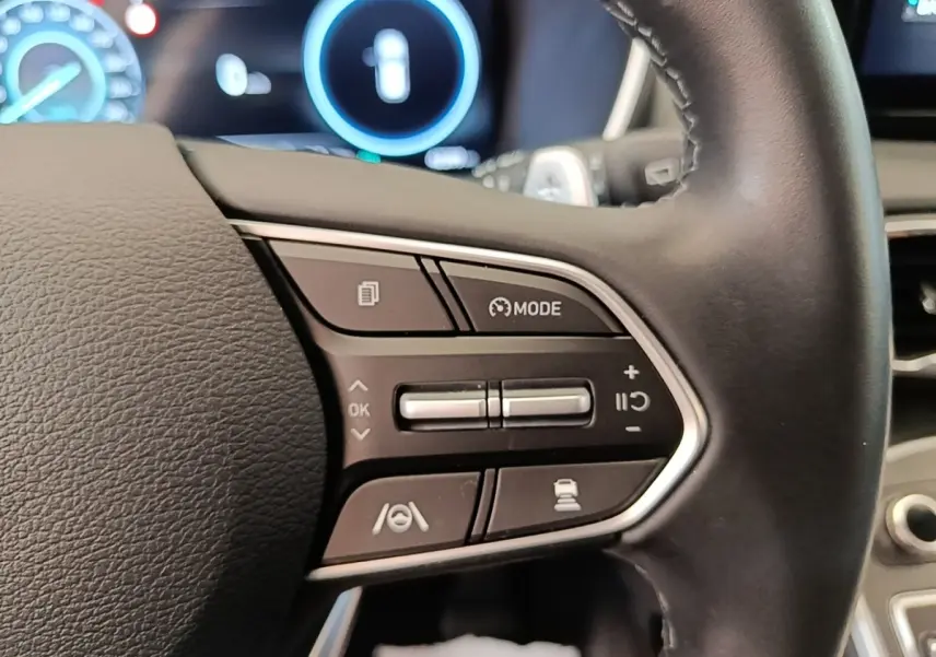 Gros plan sur les commandes multifonctions à droite du volant cuir du Hyundai Santa Fe 2023, affichage numérique en arrière-plan.