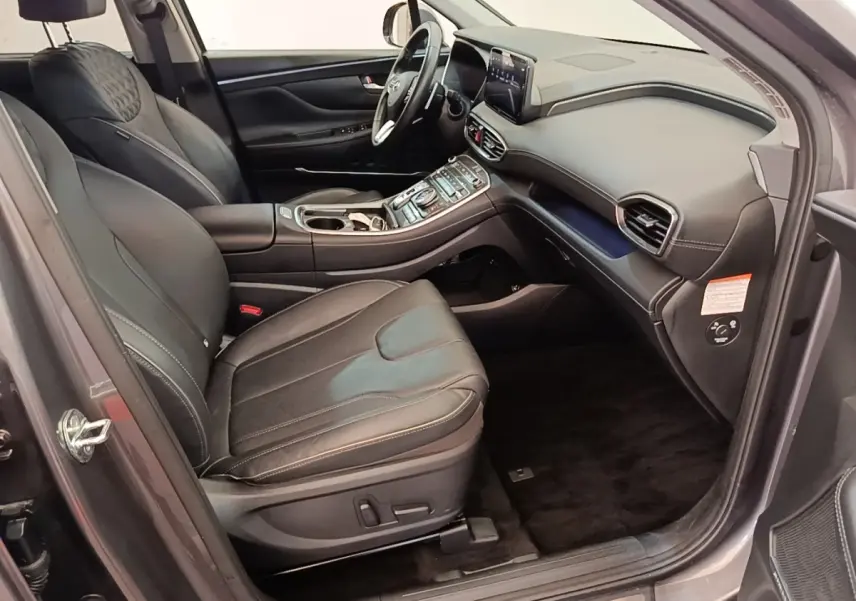 Vue intérieure côté conducteur du Hyundai Santa Fe gris foncé 2023, avec sièges cuir et tableau de bord moderne.
