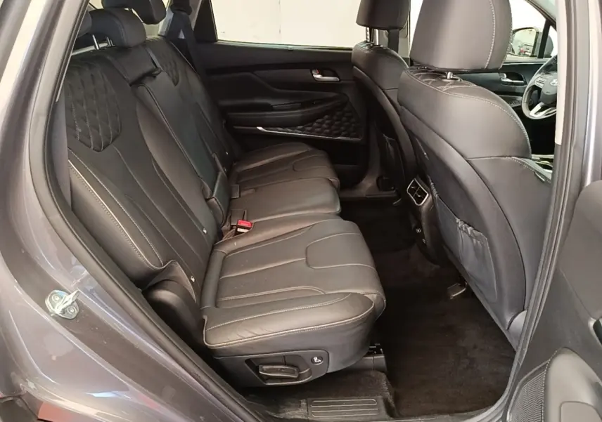 Vue intérieure côté gauche des sièges arrière en cuir noir du Hyundai Santa Fe 2023 gris foncé, avec détails couture apparents.