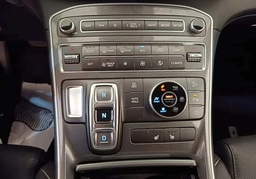Vue rapprochée de la console centrale du Hyundai Santa Fe 2023, avec commandes de boîte auto et sélection modes terrain.