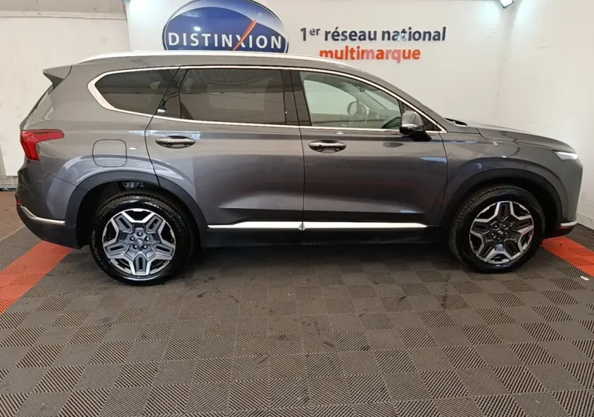 Vue latérale droite du Hyundai Santa Fe gris foncé 2023 avec jantes alliage et lignes chromées sur les portières.