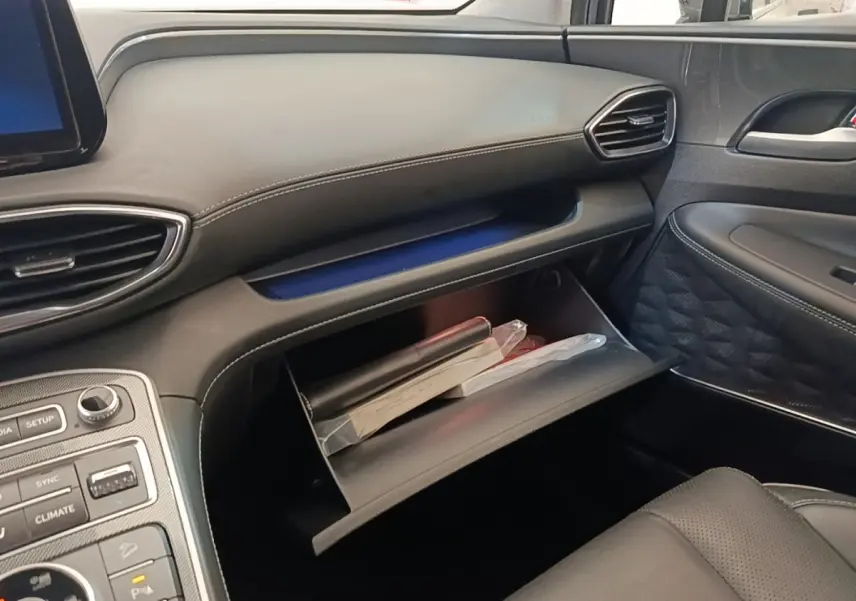Intérieur côté passager du Hyundai Santa Fe gris foncé 2023, avec boîte à gants ouverte et tableau de bord noir.