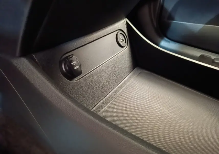 Prise 12V et bouton verrouillage dans le compartiment de rangement intérieur du Hyundai Santa Fe gris foncé.