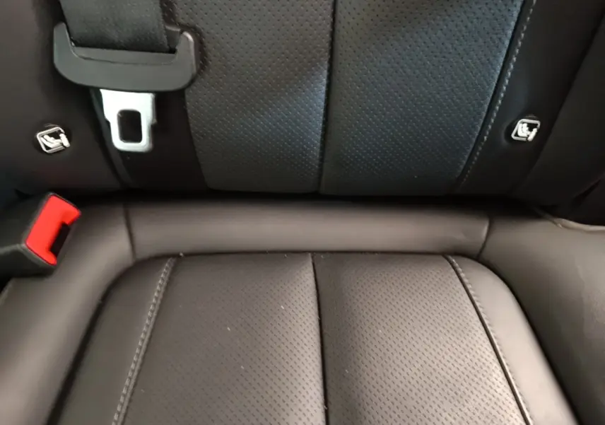 Gros plan sur la banquette arrière en cuir noir perforé du Hyundai Santa Fe 2023, avec ceintures et ancrages ISOFIX visibles.