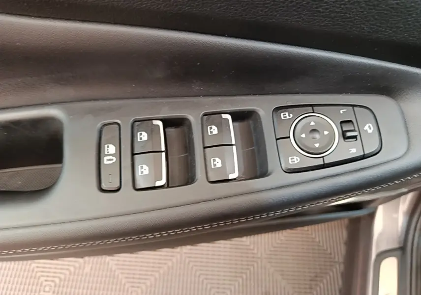 Vue rapprochée des commandes de porte côté conducteur du Hyundai Santa Fe gris foncé, avec boutons de verrouillage et réglage des rétroviseurs.