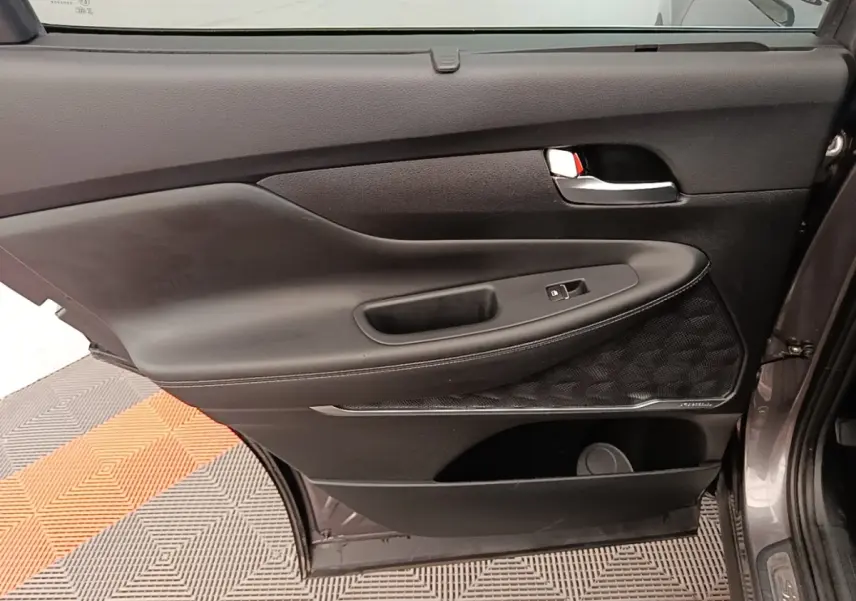 Porte arrière droite ouverte du Hyundai Santa Fe gris foncé, montrant le panneau intérieur noir avec commande de vitre.