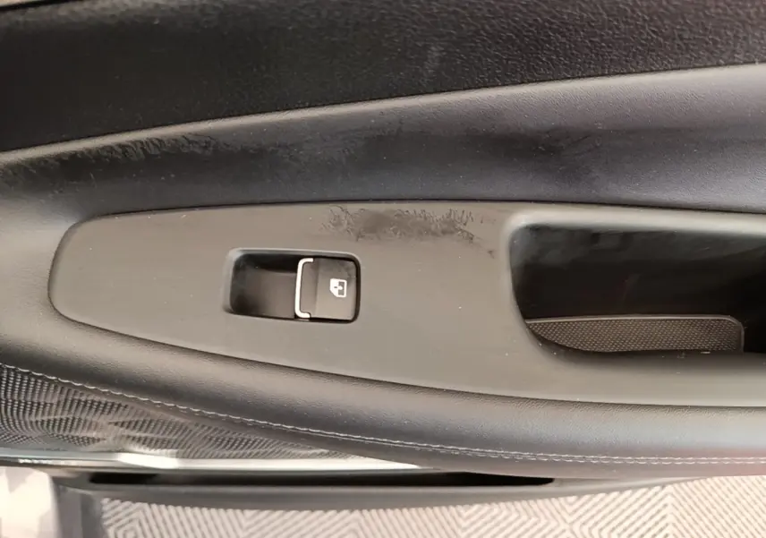 Détail de la poignée intérieure de porte côté gauche du Hyundai Santa Fe gris foncé, avec bouton de verrouillage.