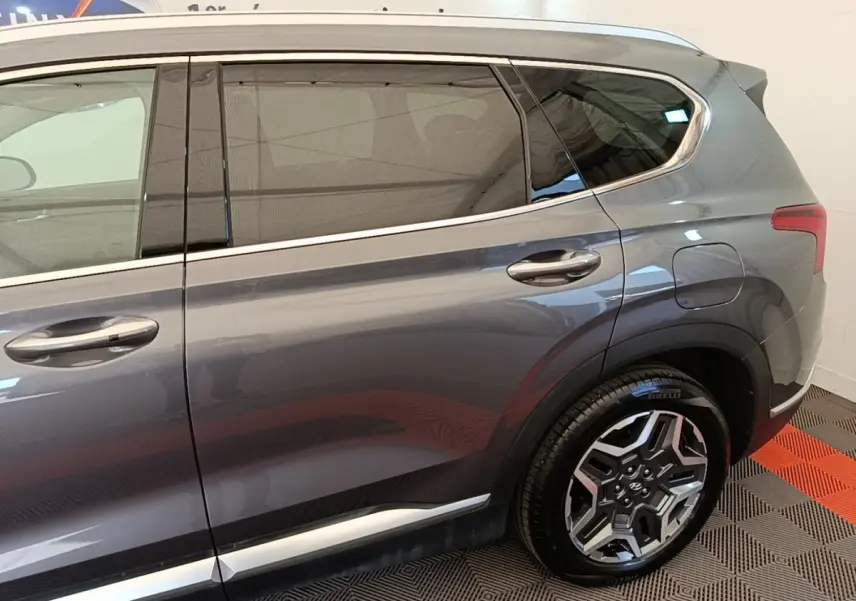 Vue latérale côté droit du Hyundai Santa Fe gris foncé 2023, mettant en valeur la jante alliage et les vitres teintées.