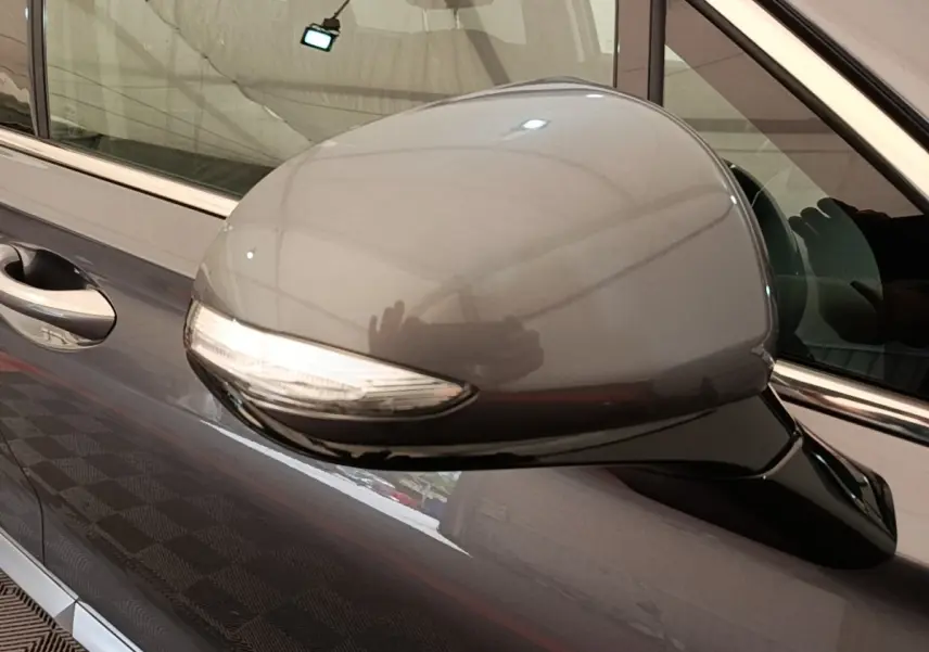 Rétroviseur côté conducteur gris foncé du Hyundai Santa Fe 2023 avec clignotant intégré, vue rapprochée côté gauche.