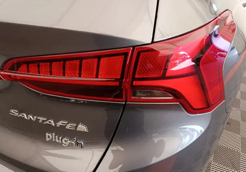 Gros plan sur le feu arrière droit et le logo Santa Fe plug-in d'un Hyundai Santa Fe gris foncé.