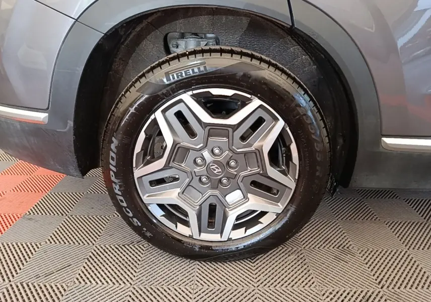 Gros plan sur la roue avant droite gris foncé du Hyundai Santa Fe 2023 avec jante alliage et pneu Pirelli Scorpion.