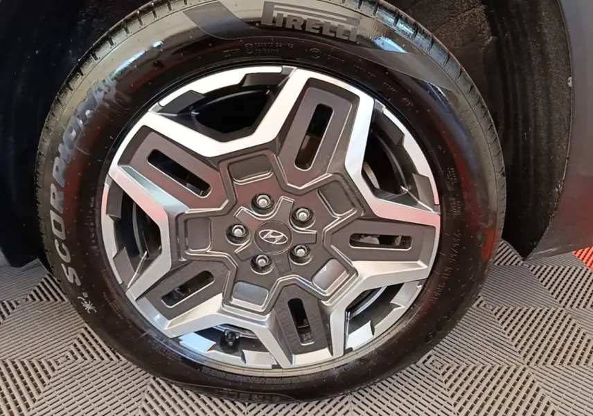 Gros plan sur la roue avant droite du Hyundai Santa Fe gris foncé, jante alliage au design moderne et pneu Pirelli.