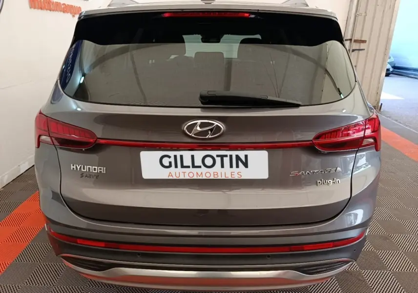 Vue arrière d’un Hyundai Santa Fe gris foncé hybride rechargeable avec feux LED et logo plug-in visibles.