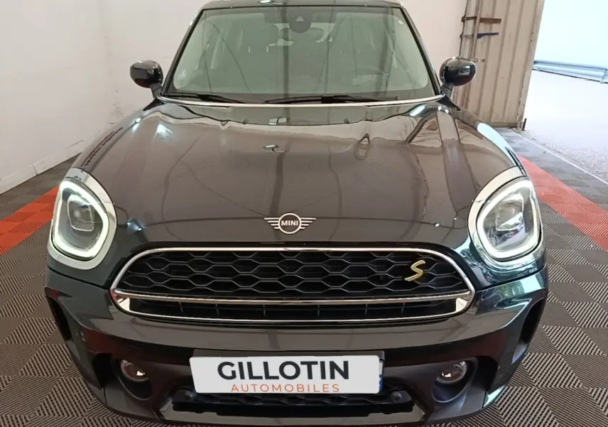 Vue avant d'une MINI Countryman noire avec phares LED allumés et calandre hexagonale distinctive.