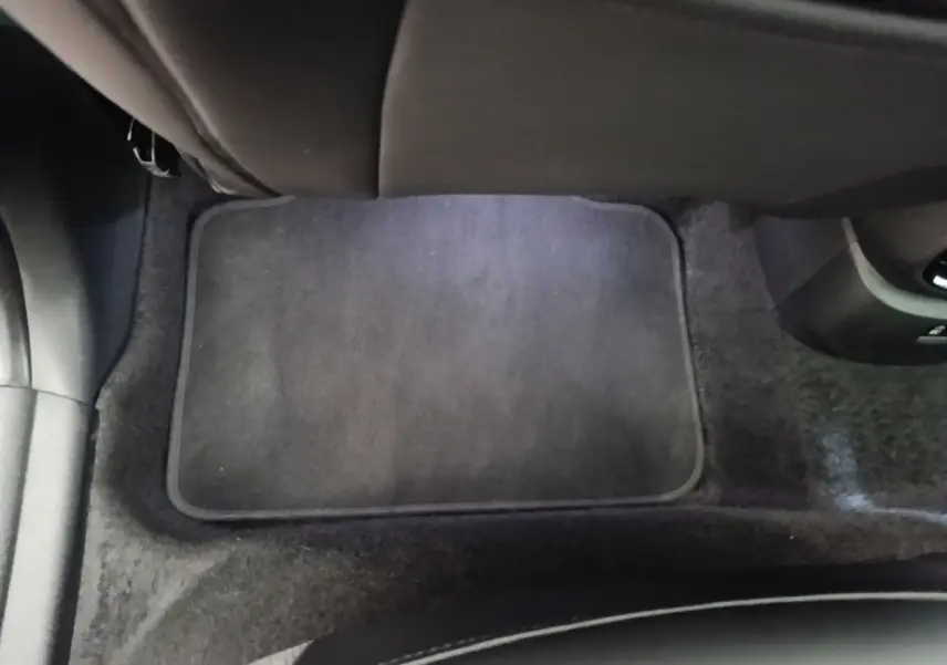 Tapis de sol noir au sol de l'habitacle arrière d'un MINI COUNTRYMAN Cooper SE 2023, vue centrée vers l'avant.