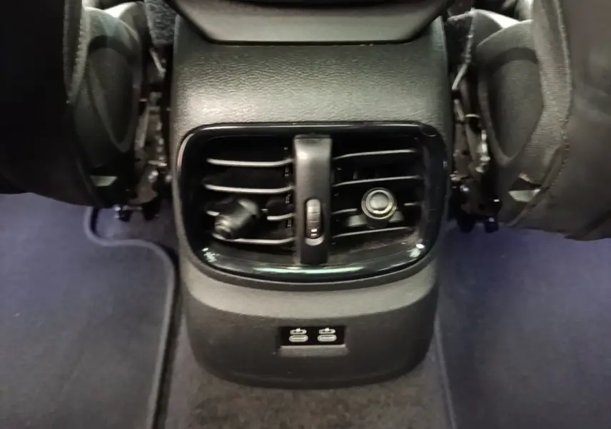 Vue rapprochée des aérateurs arrière noirs et des ports USB du MINI Countryman Cooper SE 2023, entre les sièges.