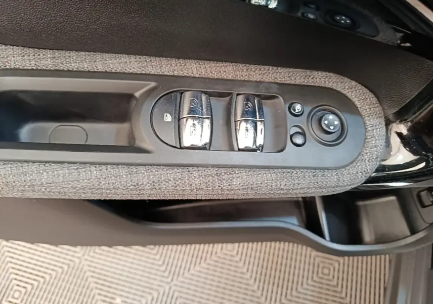 Commande des vitres et réglage des rétroviseurs sur la portière côté conducteur d'une MINI Countryman noire 2023.