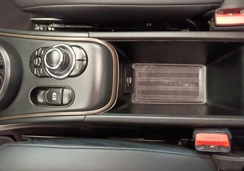Vue rapprochée de la console centrale noire du MINI COUNTRYMAN 2023 avec commandes et frein à main électrique.
