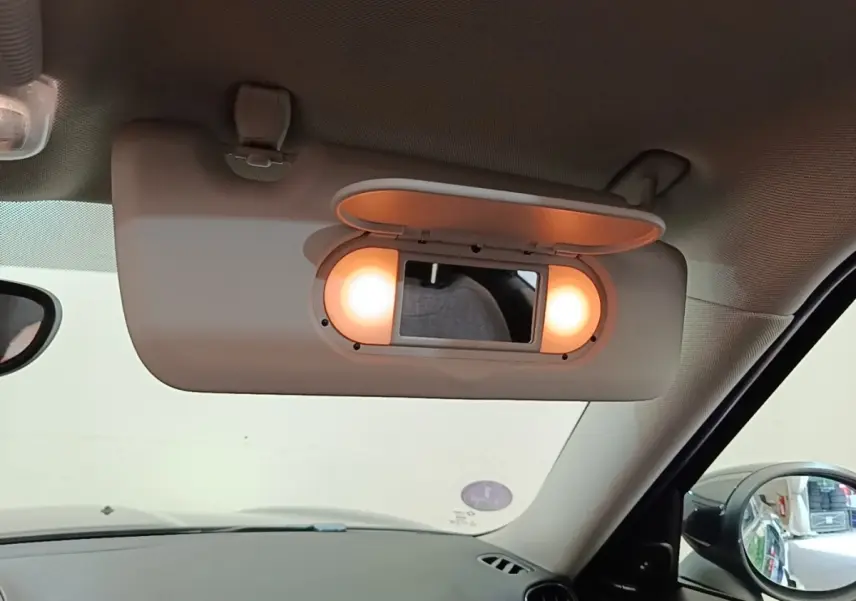 Détail du miroir de courtoisie éclairé sur le pare-soleil côté conducteur d'un MINI Countryman noir 2023 hybride rechargeable.
